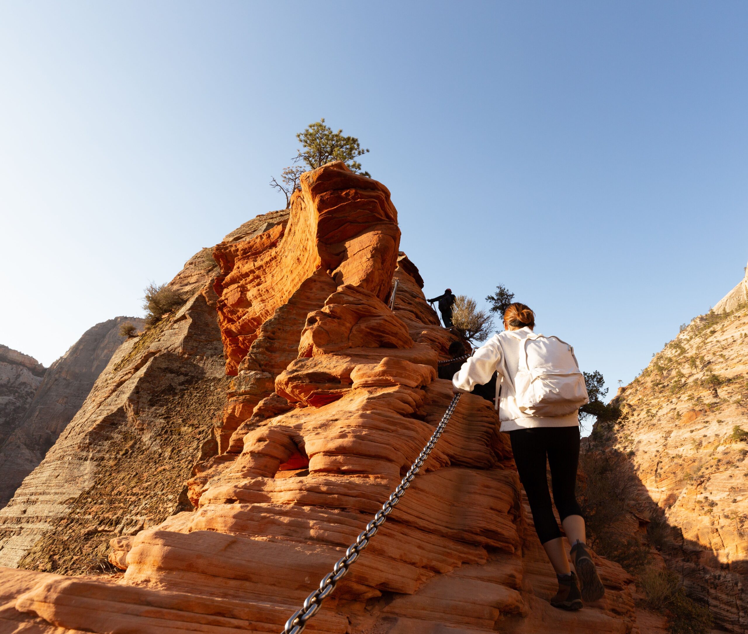 Hiker using the chains on the final exposed section of the Angels Landing trail